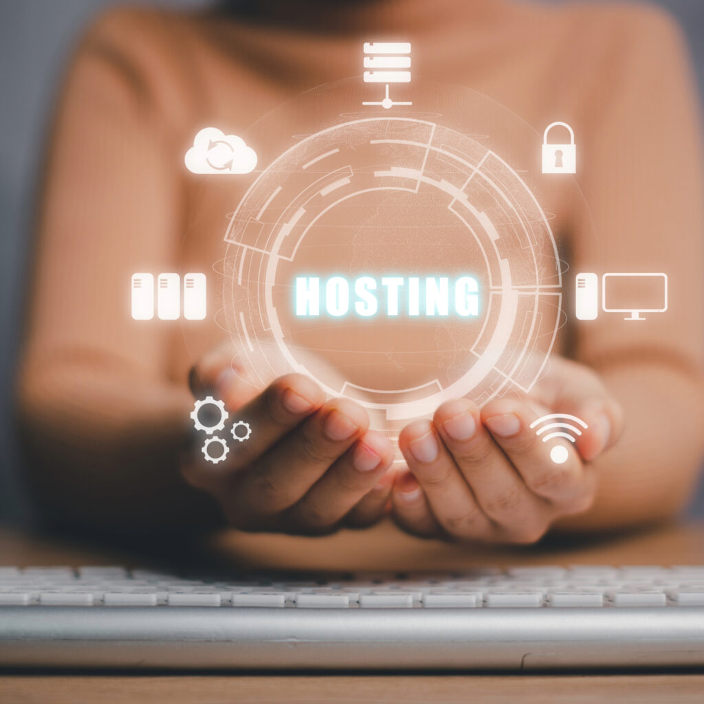 Dłonie trzymające symboliczny hologram z napisem 'Hosting', otoczone ikonami chmury, bezpieczeństwa i sieci, ilustrujące znaczenie wyboru odpowiedniego hostingu dla e-commerce w okresie Black Friday i świątecznych promocji.